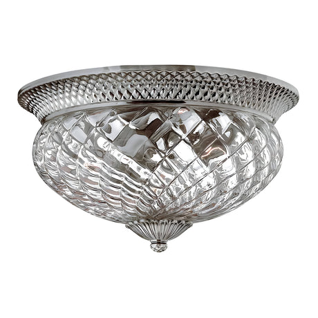 This decorative flush mount ceiling light, officially known as the Plantation 3 Light Large Flush - Polished Antique Nickel, features a diamond-patterned, pineapple-shaped clear optic glass shade and a polished antique nickel rim. Its classic design enhances any space with a vintage touch and elegant appeal.