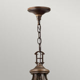 Close-up view of the Plymouth 15 Light Chandelier in a vintage-inspired bronze finish, featuring a chain link attachment to the ceiling. The focus is on the ceiling mount and the beginning of the fixture, set against a plain background.