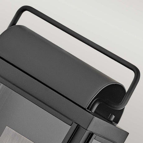 Close-up of a portable grill with a sleek black handle and smooth gray lid, exuding modern elegance akin to the Sag Harbor Outdoor 2 Light Medium Wall Lantern - Black.