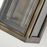 Close-up of the Sag Harbor Outdoor 2 Light Medium Wall Lantern – Painted Burnished Bronze, featuring a burnished bronze frame and rectangular glass panels that reveal cylindrical light fixtures inside. Positioned at an angle, this weather-resistant piece highlights its sleek and modern design.