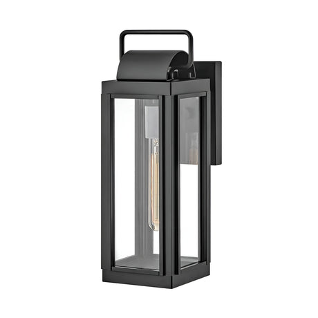 The Sag Harbor Outdoor 1 Light Small Wall Lantern in black is a contemporary fixture made from durable aluminum, featuring a clear glass exterior with a rectangular design and a top handle. The visible bulb is set within a vertical mount, and its IP44 rating guarantees style and dependability for any outdoor space.