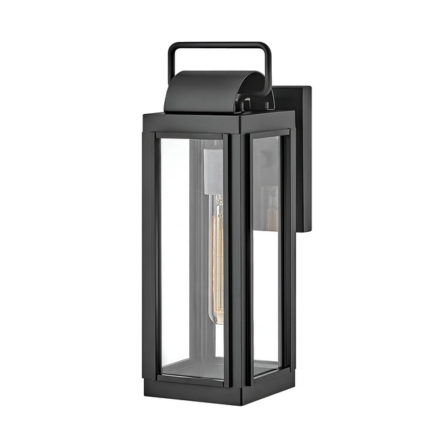 The Sag Harbor Outdoor 1 Light Small Wall Lantern in black is a contemporary fixture made from durable aluminum, featuring a clear glass exterior with a rectangular design and a top handle. The visible bulb is set within a vertical mount, and its IP44 rating guarantees style and dependability for any outdoor space.