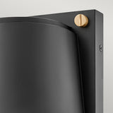 Close-up of the Scout Outdoor 1 Light Small Wall Light - Black, featuring a modern black metal structure with a weather-resistant finish and a sleek curved design. A contrasting round wooden accent is visible at the top right corner, affixed to a rectangular backplate. This minimalist outdoor wall light stands elegantly against a light background.