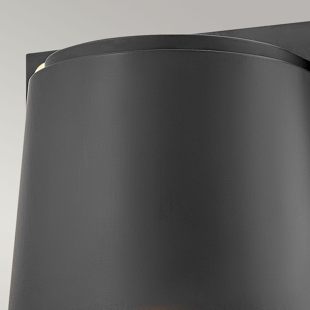 A close-up of the Scout Outdoor 1 Light Small Wall Light in black, featuring a cylindrical shape against a light gray background. This minimalist design showcases smooth surfaces and modern aesthetics, while ensuring weather-resistant durability.