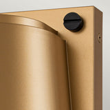 Close-up of a contemporary gold-colored wall sconce resembling the Scout Outdoor 1 Light Small Wall Light - Painted Heritage Brass, showcasing a cylindrical design and a black circular knob at the top. Its Painted Heritage Brass finish contrasts elegantly with the plain off-white wall.