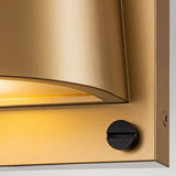 Close-up of the Scout Outdoor 1 Light Small Wall Light in painted heritage brass with a sleek, curved design. A black knob on the right side contrasts with the fixture, while warm light highlights its texture, merging elegance with functionality for impeccable outdoor lighting.