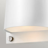 A close-up of the Scout Outdoor 1 Light Small Wall Light showcases its modern design. It has a sleek satin white finish and a cylindrical shade paired with a metallic silver base featuring a visible screw. This wall light casts soft, warm illumination from underneath, making it perfect for outdoor spaces. It's IP44 rated and elegantly stands out against the light grey background.