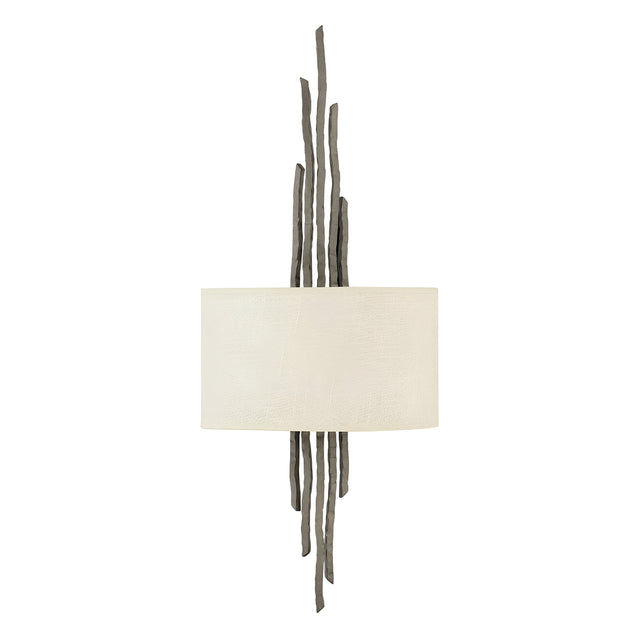 The Spyre 2 Light Wall Light features a modern design with a cylindrical white shade and sculptural dark metal rods in a metallic matte bronze finish, extending vertically from both the top and bottom for an artistic and contemporary look.