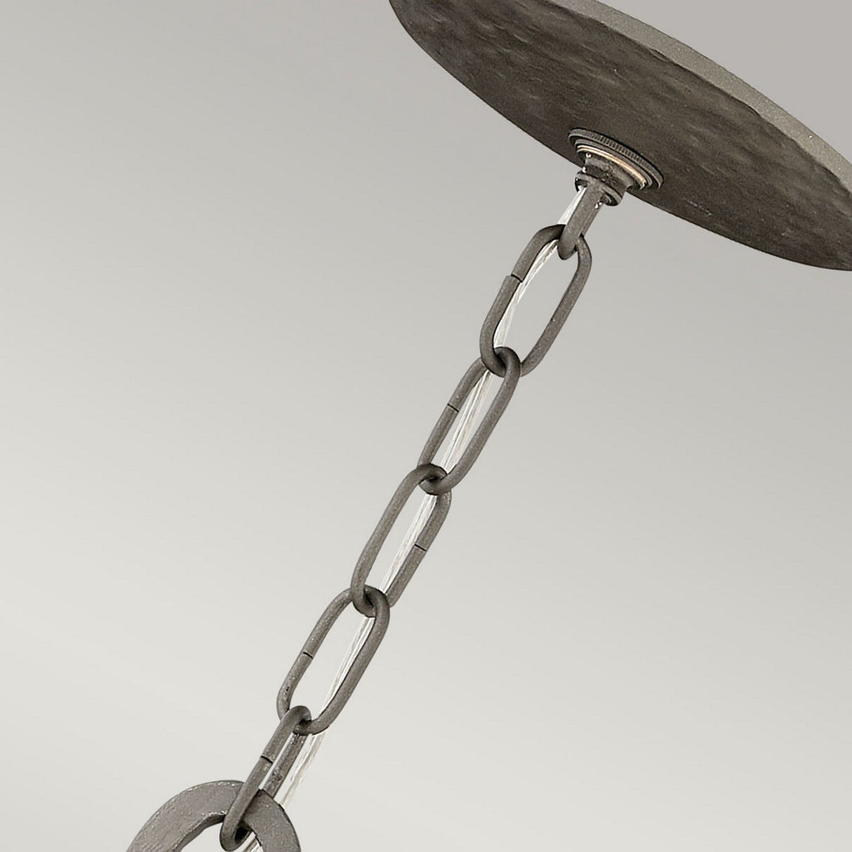 Here's a rephrased version of the sentence incorporating the given product data:

A close-up view showcases the Spyre 6 Light Pendant in a metallic matte bronze finish, suspended from a round ceiling fixture. This sculptural piece introduces an industrial charm to the lighting arrangement within the space, set against a neutral, light-colored background.