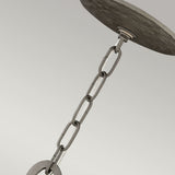 Here's a rephrased version of the sentence incorporating the given product data:

A close-up view showcases the Spyre 6 Light Pendant in a metallic matte bronze finish, suspended from a round ceiling fixture. This sculptural piece introduces an industrial charm to the lighting arrangement within the space, set against a neutral, light-colored background.