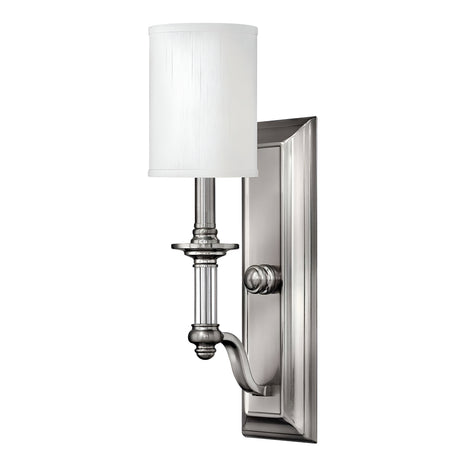 Introducing the Sussex 1 Light Wall Light in Brushed Nickel, a sleek and modern wall sconce that exudes timeless elegance. This fixture features a brushed nickel finish paired with a cylindrical white fabric shade. Its design includes an elegant curved arm and a rectangular backplate, making it the perfect addition to any contemporary interior decor.