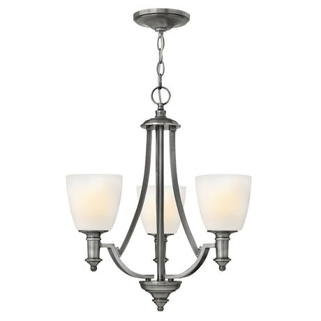 The Truman 3 Light Chandelier - Antique Nickel features a timeless design with gracefully curved arms extending from a central column. It is adorned with etched opal glass shades and elegantly hangs from a chain, perfectly showcasing its antique nickel finish.