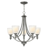 The Truman 5 Light Chandelier - Antique Nickel showcases elegance with its antique nickel finish and etched opal glass shades. Designed with gracefully curved arms and a circular base, it's ideal for both dining and living spaces.