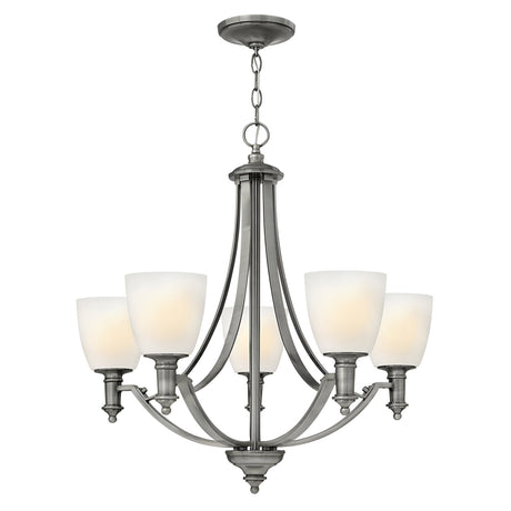The Truman 5 Light Chandelier - Antique Nickel showcases elegance with its antique nickel finish and etched opal glass shades. Designed with gracefully curved arms and a circular base, it's ideal for both dining and living spaces.
