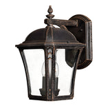 The Wabash Outdoor 2 Light Medium Wall Lantern - Bronze is a rustic wall lantern with a glass panel design. It features an ornate top finial and a curved arm, accommodating two bulbs. With its vintage aesthetic and subtle chevron design, it is ideal for enhancing your exterior décor.