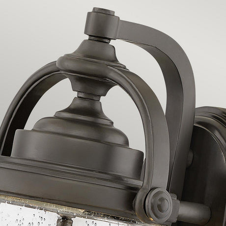 Close-up of the Willoughby 2 Light Wall Lantern in oil rubbed bronze, featuring a detailed metal frame and clear seeded glass panels. The finish enhances the curved design and intricate metalwork, giving it a classic, elegant look against a neutral background.