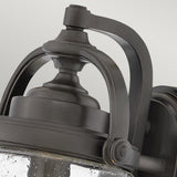 Close-up of the Willoughby 1 Light Wall Lantern, featuring a vintage-style curved metal frame and clear glass. The oil rubbed bronze finish and elegant design enhance the classic aesthetic, making it perfect for outdoor lighting.