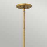A close-up of the Zelda 1 Light Mini Pendant in Vintage Brass against a neutral background. The pendant features a rod extending down from a round, flat canopy, highlighting its simple and sleek mid-century design that adds timeless elegance to any space.