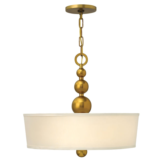 The Zelda 3 Light Pendant - Vintage Brass showcases a sleek, contemporary style with its modern brass pendant frame and fabric drum shade. The fixture is enhanced by three elegant brass spheres on the chain and a smaller one below, effortlessly merging with mid-century design elements.
