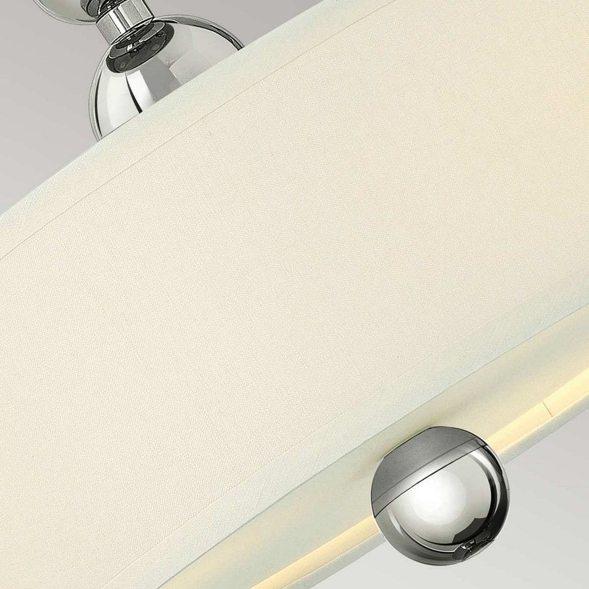Here's a rephrased version of the sentence using the product data:

A close-up of this Zelda 3 Light Semi Flush fixture showcases its modern design with a polished nickel finish and a white fabric lampshade. The spherical chrome accent at the base enhances its style, while the fabric shade softly diffuses light to create a gentle glow.