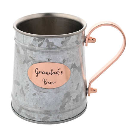 Iron Moscow mule mug in mottled silver-grey with raised rim bands, a copper-coloured handle, and an oval plaque reading "Grandad's Beer", shown on a white background.