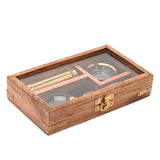 Brown wood hinged case with glass lid and gold clasp holding a round magnifier, slim telescope, and compass on black lining.