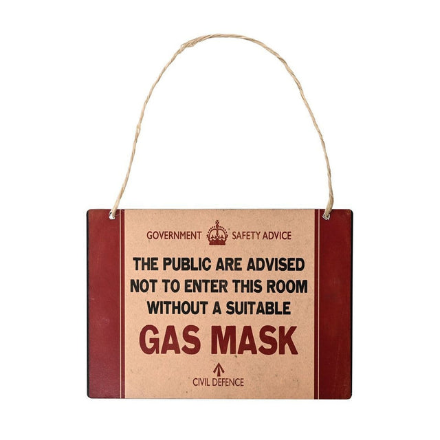 Metal wall plaque with beige centre panel and red borders, reading Government Safety Advice: do not enter this room without a suitable gas mask, with crown emblem, hung on twine.
