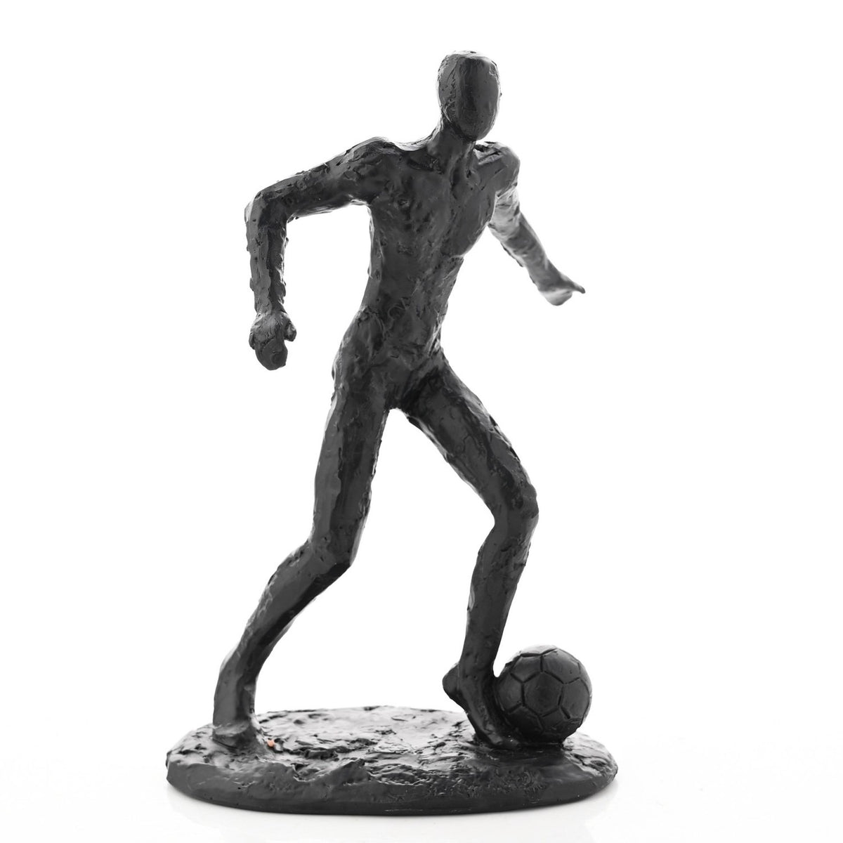 Black resin footballer figurine with textured surface, faceless head, and long limbs, mid-stride with one foot on a football, set on an oval base against a white background.