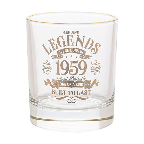 Clear glass tumbler with a gold rim, printed in gold text "Legends were born in 1959, Aged Perfectly, One of a Kind, Built to Last" within a vintage scroll design, shown on a plain white background.