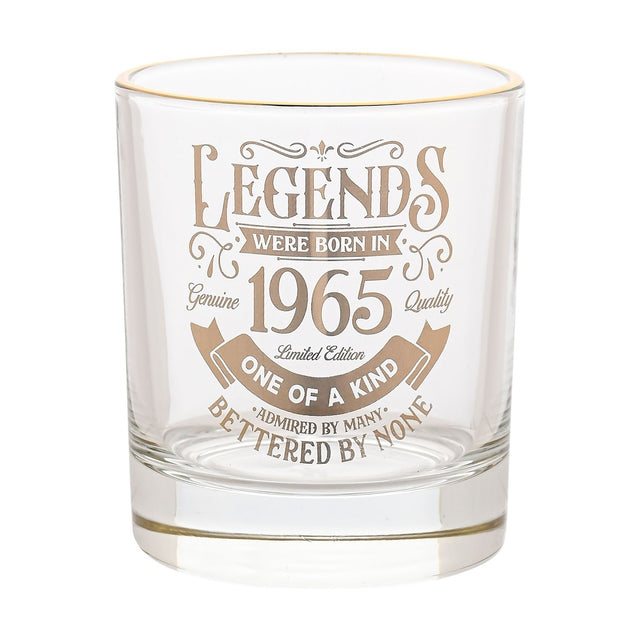 Clear glass tumbler with gold rim and gold "Legends were born in 1965" vintage lettering with scrolling flourishes, shown on a plain white background.