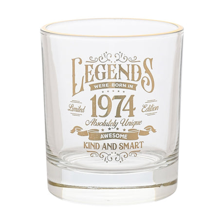 Clear glass tumbler with gold rim, printed in gold with "Legends were born in 1974" vintage lettering and scrollwork, on a plain white background.