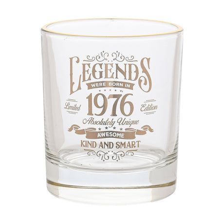 Clear glass tumbler with gold rim, printed with "Legends Were Born in 1976" vintage label design in gold text, shown on a plain white background.