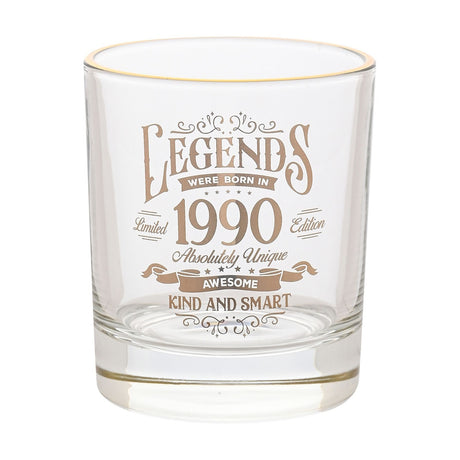 Clear glass tumbler with gold rim and gold "Legends were born in 1990" print, featuring scrolled text "Absolutely Unique, Awesome, Kind and Smart", on a plain white background.