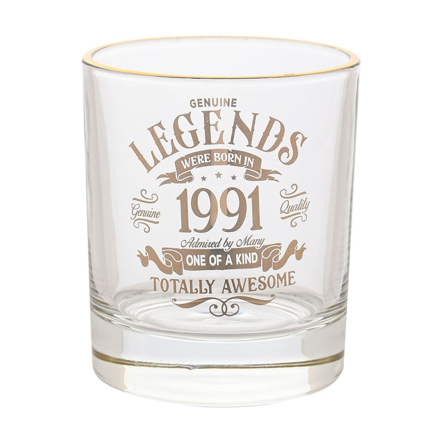 Clear glass whisky tumbler with gold rim, printed in gold text "Legends Were Born In 1991, One of a Kind, Totally Awesome," on a plain white background.