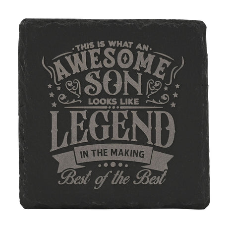 Square black slate coaster with engraved grey text reading "This is what an awesome son looks like, Legend in the making, Best of the Best," framed by stars and scrollwork.