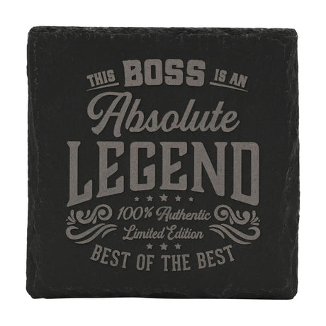 Black square slate coaster with grey engraved text reading "This Boss Is An Absolute Legend, Best of the Best," framed by stars and scrollwork, on a white background.