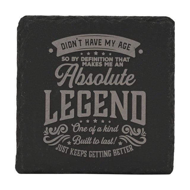 Square black slate coaster with grey engraved text reading "Didn't Have My Age Absolute Legend," framed by stars and flourishes, on a white background.