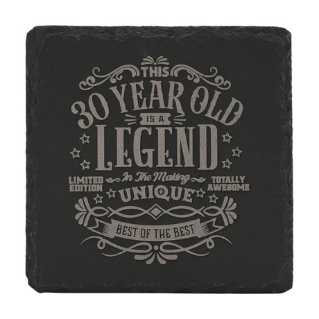 Square black slate coaster with raw edges, engraved in grey with This 30 Year Old Is a Legend In The Making text surrounded by stars and scroll flourishes, on a white background.