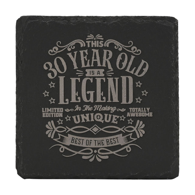 Square black slate coaster with raw edges, engraved in grey with This 30 Year Old Is a Legend In The Making text surrounded by stars and scroll flourishes, on a white background.