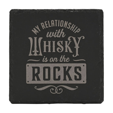 Square black slate coaster engraved with "My Relationship with Whisky Is on the Rocks" in pale grey lettering, ROCKS set in a plaque panel, shown on a white background.