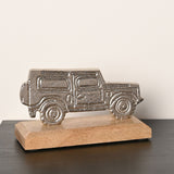 4X4 Vehicle Metal Figurine with Base in silver, a flat textured silhouette on a natural wood base, shown on a dark surface against a plain light background.
