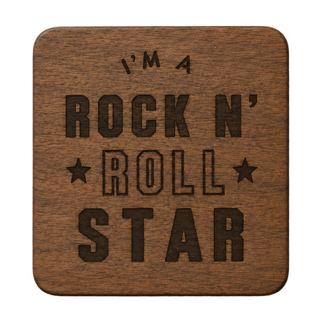 Rounded square wooden coaster in tan with natural grain, engraved with "I'm A Rock N' Roll Star" in bold dark brown lettering and two small stars, on a plain white background.