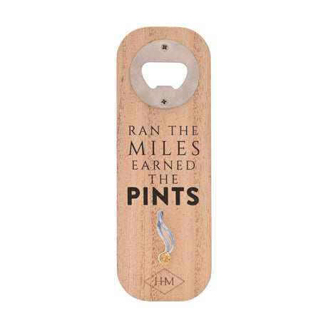 Wooden bottle opener in natural rounded-rectangle wood with silver metal opener fitting, text "Ran the Miles Earned the Pints" and a blue and gold medal motif, shown on a plain white background.
