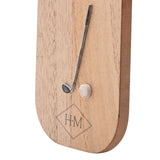 Close-up of the Putt Parr & Pints wooden bottle opener showing a raised metallic golf club and cream ball detail above an engraved H-M diamond logo on natural wood.