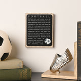 Football Wooden Plaque with Ball Motif in black and natural wood, hung on a wall beside books, a football and a boot-shaped bookend.