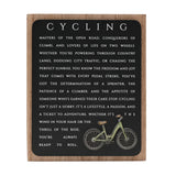 Cycling Wooden Plaque with Green Bicycle, a rectangular wall art sign in black and natural wood finish featuring white cycling-themed text, shown on a plain white background.