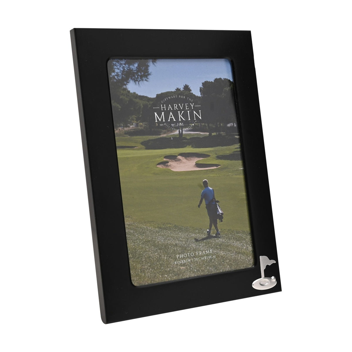 Rectangular matt black metal photo frame with a silver golf flag and ball emblem in the lower right corner, holding a 6 x 4in golf course photo, shown on a white background.