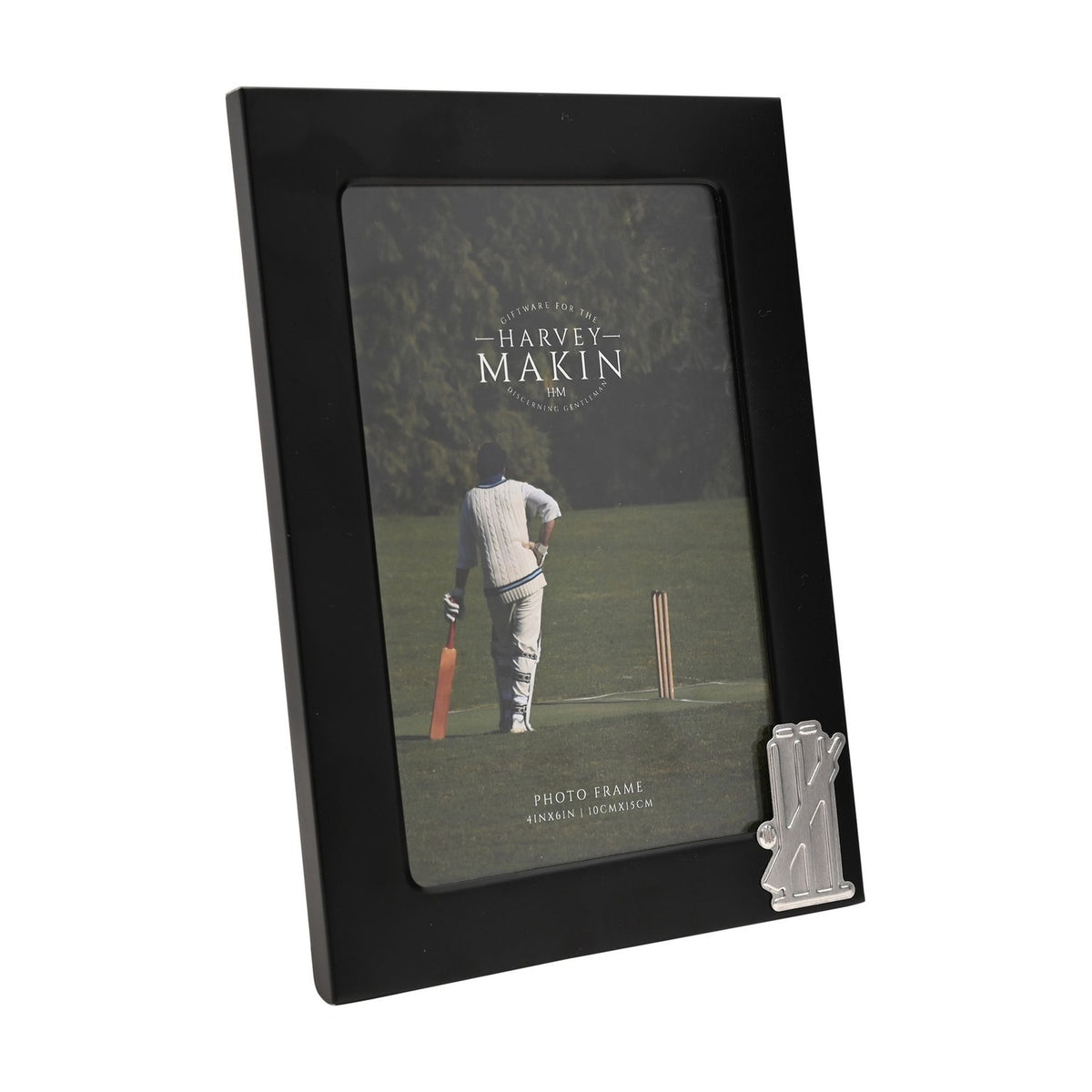 Black metal rectangular photo frame for a 6 x 4in picture, with a silver cricket stumps, bails and bat emblem on the lower right corner, shown on a white background.