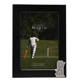 Black metal rectangular photo frame for a 6 x 4in picture, with a silver cricket stumps, bails and bat emblem on the lower right corner.