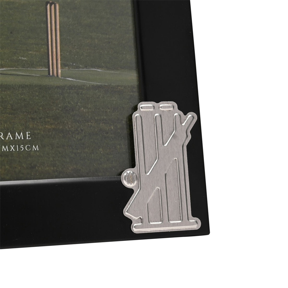 Close-up of the Cricket Stumps Metal Photo Frame 6 x 4in in black with a silver cricket stumps, bails and bat emblem on the corner, holding a pitch photograph.